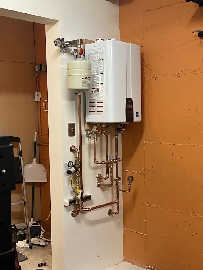 Plumbing technician inspecting water heater connections in Rock Valley
